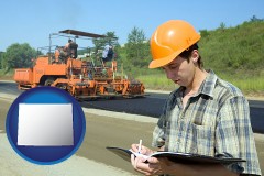 wyoming map icon and a civil engineer inspecting a road building project